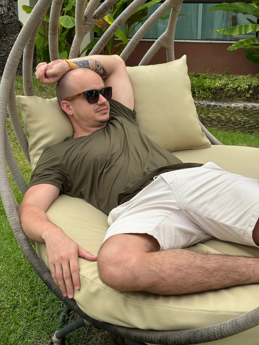 Fred, criador do canal Fred Invest, recostado em uma cadeira suspensa ao ar livre